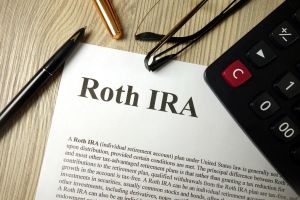 Roth IRA document on a desk with a calculator and pen, representing smart retirement planning with a lump sum investment.